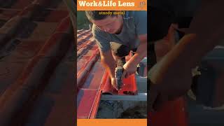 A worker installs roof tiles securely screwing them onto a sturdy metal frame for durability [upl. by Nairadal677]