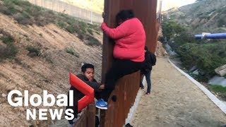 Migrant families continue to spill over Tijuana border fence head to US [upl. by Karolina250]