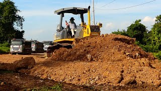 Dump trucks and Komatsu bulldozer machine work busily to build the village road [upl. by Pages]