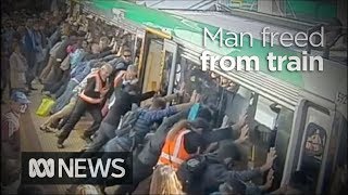 Faith in humanity restored as crowd lift train to save trapped man 2014  ABC News [upl. by Blaire]