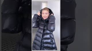 A girl in black elongated Moncler puffer down jacket with deep hood Black Moncler long down jacket [upl. by Ivanah]