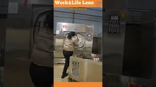 Woman loads dirty laundry into an industrial washer at a laundromat then moves it to a rolling crate [upl. by Anileme]