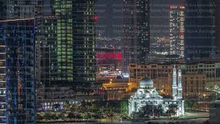 New white mosque near bay avenue surrounded by skyscrapers in Business Bay district night timelapse [upl. by Aihsekram]